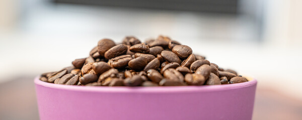 Organic natural coffee beans in a pink bowl