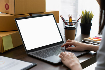 Hand using a computer laptop with a blank screen on table, for putting advertising to promote