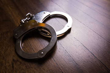 Handcuffs concept on a table with guns of different caliber