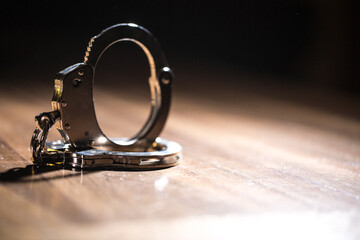 Handcuffs concept on a table with guns of different caliber