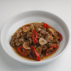 Stir fry beef with garlic, onion and chili in white plate