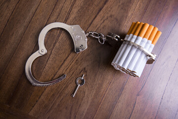 Cigarettes attached to a handcuff and hand, as in attached to your self and cant quit