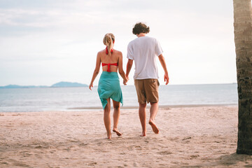 Back Side of Romantic Couple Enjoying Summer Walk on the Beach at Sunset