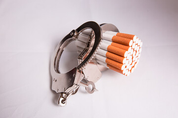 Cigarettes attached to a handcuff and hand, as in attached to your self and cant quit