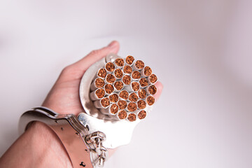 Cigarettes attached to a handcuff and hand, as in attached to your self and cant quit