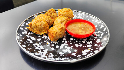 Tahu walik, tofu walik traditional Indonesian food, on a black table, aesthetic modern outdoor cafe menu, when the weather is cloudy.