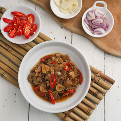 Stir fry beef with garlic, onion and chili in white plate