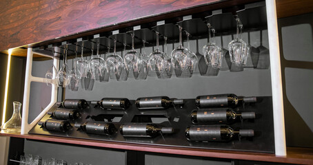 Wine bottles and glassware on sleek wall rack display