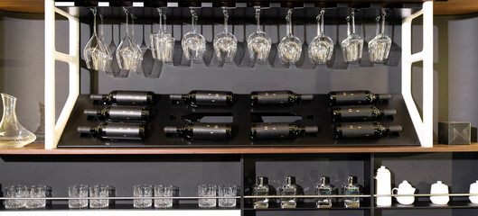 Wine bottles and glassware on sleek wall rack display