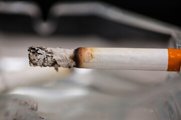 Burning cigarette with smoke and concept of cigarettes 
