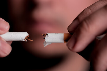 Concept image of a man cutting the habit of quitting smoking. Burning cigarette with smoke and concept of cigarettes 