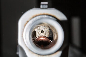 Macro view of weapon barrel with bullet at the end