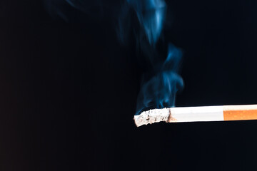 Burning cigarette with smoke and concept of cigarettes 
