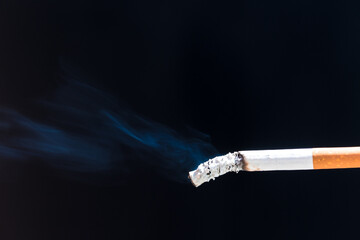 Burning cigarette with smoke and concept of cigarettes 