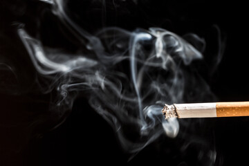 Burning cigarette with smoke and concept of cigarettes 