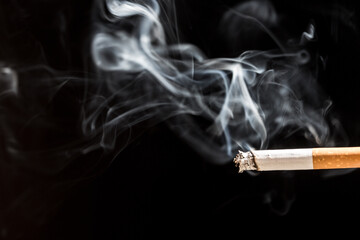 Burning cigarette with smoke and concept of cigarettes 