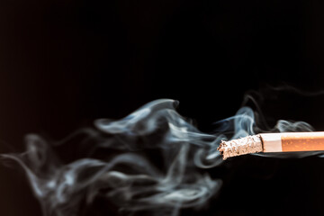 Burning cigarette with smoke and concept of cigarettes 