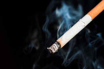 Burning cigarette with smoke and concept of cigarettes 