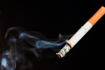 Burning cigarette with smoke and concept of cigarettes 