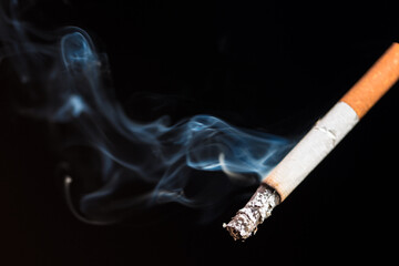 Burning cigarette with smoke and concept of cigarettes 