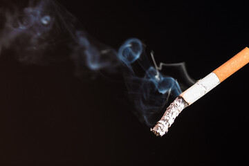 Burning cigarette with smoke and concept of cigarettes 