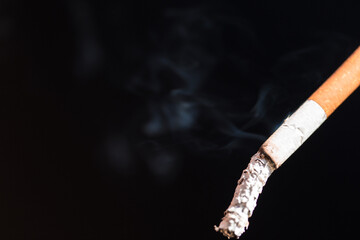 Burning cigarette with smoke and concept of cigarettes 
