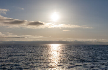 The sun is shining on the ocean, creating a beautiful reflection