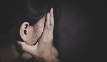 Sad and depressed woman sitting on sofa at home.Stop violence against women,  Domestic abuse victim. Suicide due to depression.