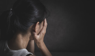 Sad and depressed woman sitting on sofa at home.Stop violence against women,  Domestic abuse victim. Suicide due to depression.