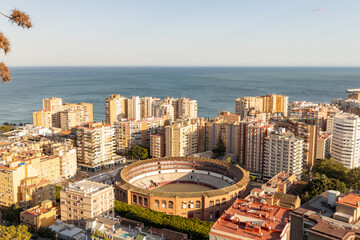Bull Ring, Plaza la Malagueta, Andalusia, Spain. Aerial view of urban landscape featuring a historic bullring surrounded by modern buildings and ocean backdrop