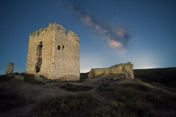 starry night sky with the milky way over an abandoned castle