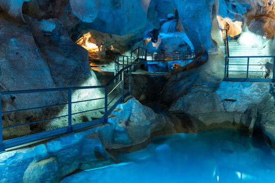 Cueva del Tesoro. Stunning cave interior with illuminated pathways and tranquil water pools, showcasing natural rock formations and serene atmosphere