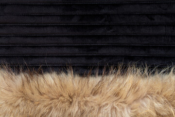 Brown fur collar on black velour background, textile texture for background, fashion