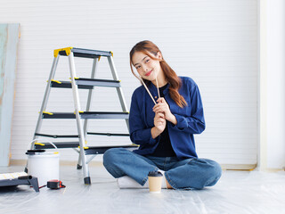 Asian young beautiful woman long curly hair wearing blue shirt jeans posing sitting back in ladder...