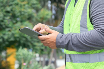 Asian overweight construction project foreman wearing white hard hat and reflective safety vest...