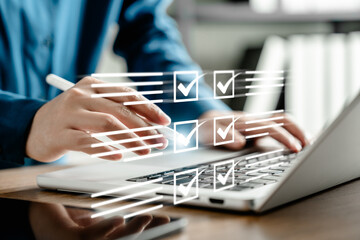 Businesswoman managing digital checklist on laptop with virtual tick boxes, planning and...