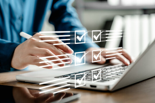 Businesswoman managing digital checklist on laptop with virtual tick boxes, planning and productivity concept, hand using stylus for project organization and efficient task management in modern office