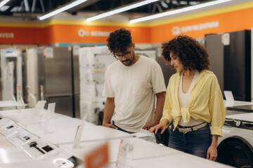 Obraz premium Couple Exploring Appliance Options in a Modern Electronics Store