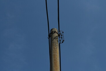 Obraz premium Electrical pole with electrical cables on a beautiful blue sky background 