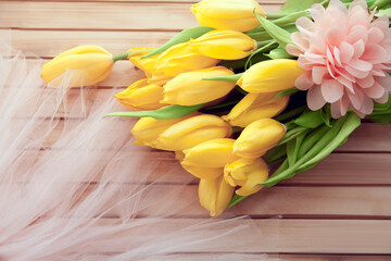 bouquet of yellow tulips on wooden background