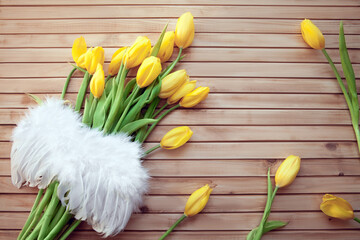 bouquet of yellow tulips with Angel winds on a  wooden background
