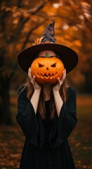 Naklejka premium Photo of Woman in Witch Costume Holding Carved Pumpkin During Autumn Celebration