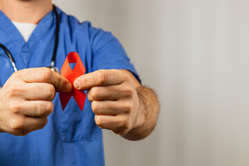 Medical professional holds red ribbon symbolizing awareness and support