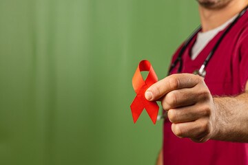 Health advocate holds orange awareness ribbon against green background
