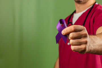 Healthcare worker with a purple ribbon for cancer research support