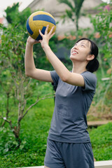 Obraz premium Young athlete practicing volleyball skills outdoors in a lush green environment with a focus on teamwork and dedication