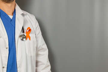 Medical pro in white coat with orange ribbon for awareness