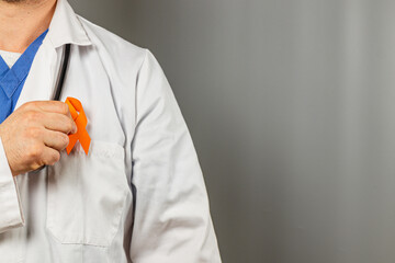 Healthcare professional displays orange ribbon for awareness campaign