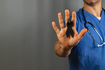 Healthcare worker holding a black ribbon to honor those affected by loss
