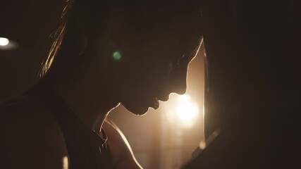 Closeup portrait of tired female athlete leaning on punching bag, breathing hard . Self-defense and cardio for stay healthy and active, do sport for keeping fit, woman fighter preparing to competition